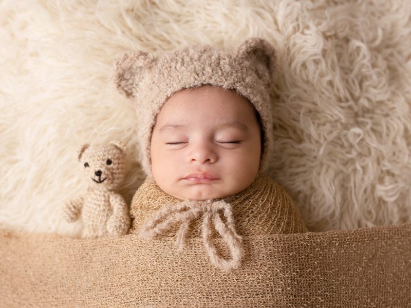 photo-of-baby- with-a-teddy-bonnet-and matching-teddy-sleeping