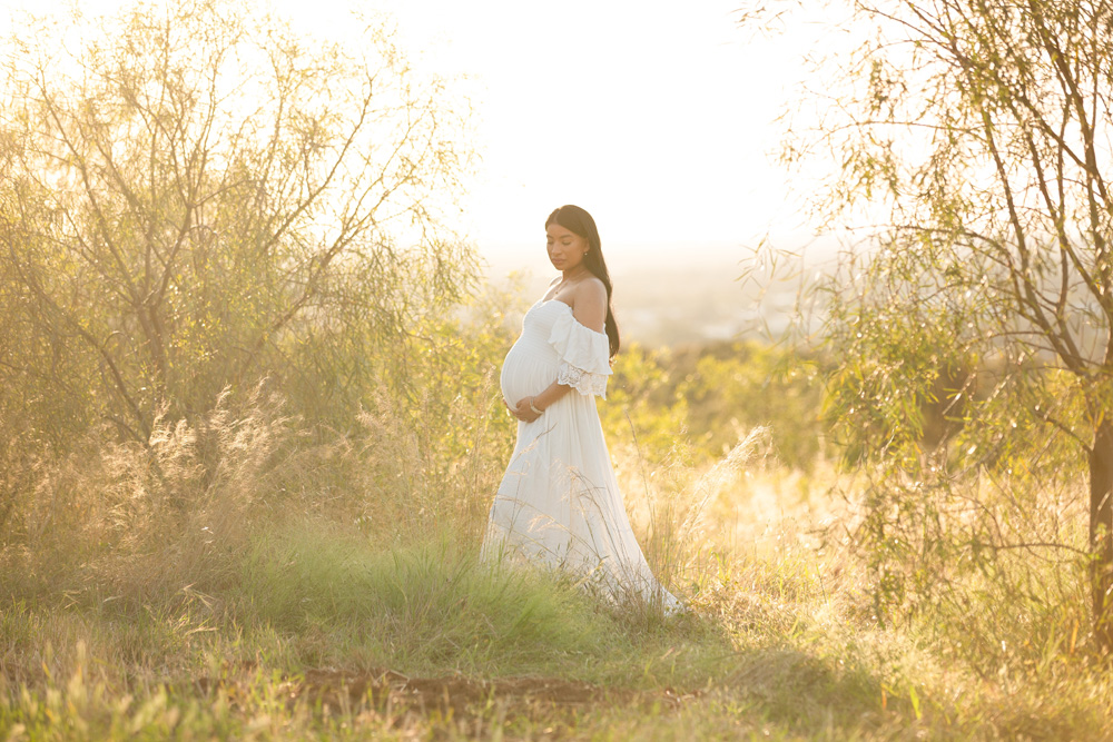 pregnant-woman-at-her maternity-session-wearing-a-white-dress