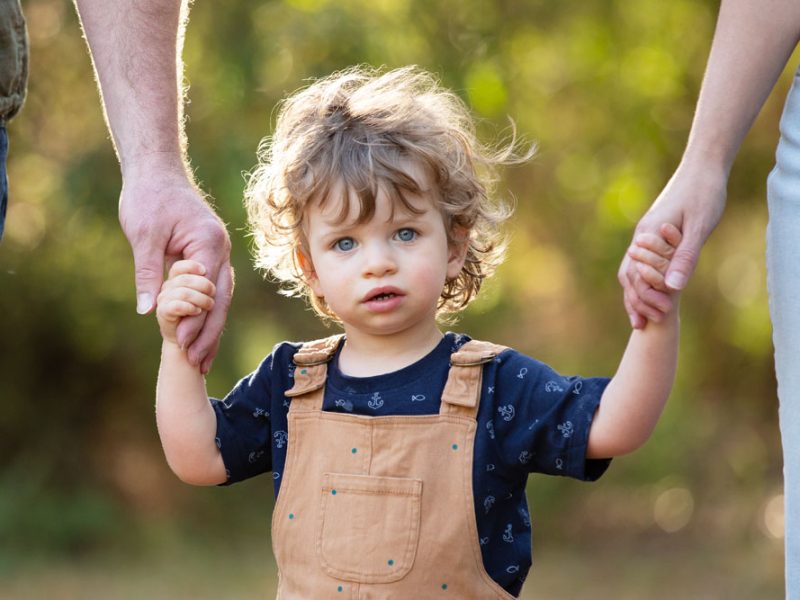 little_boy_holding_parents_hands